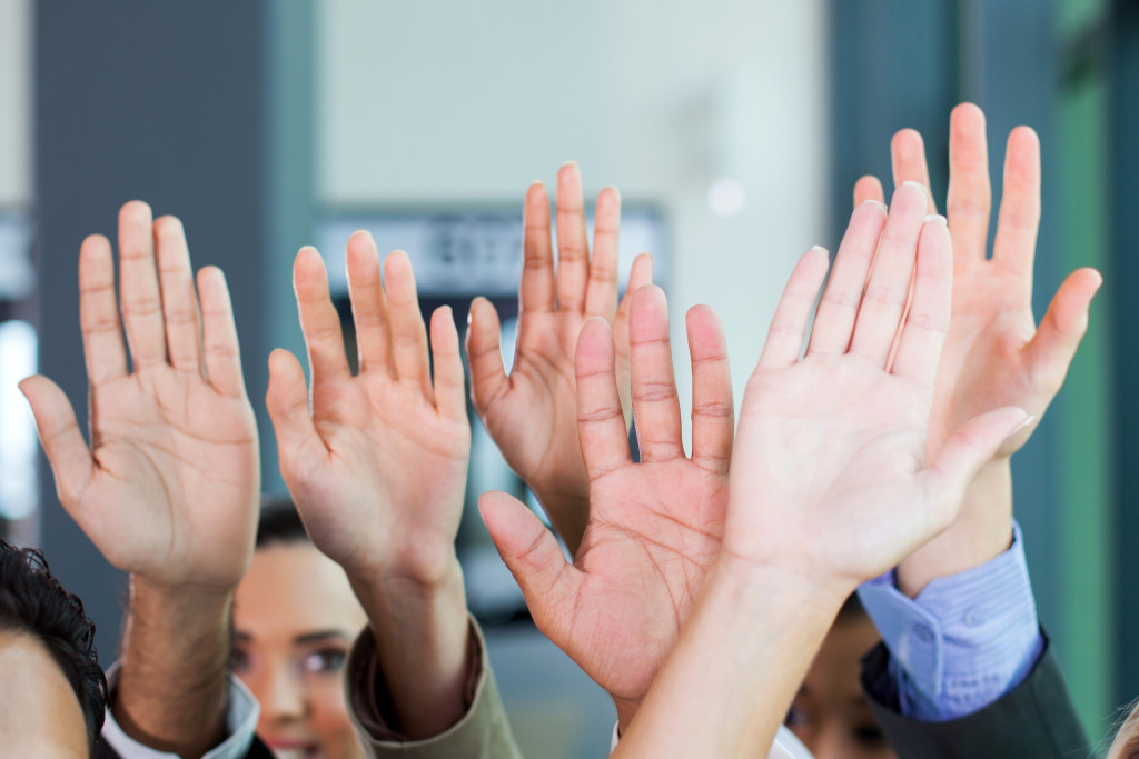 people raising hands showing palms